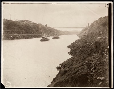 Ansicht von zwei Booten im Panamakanal während des Baus mit einer Hängebrücke dahinter, 1913 von Byron Company